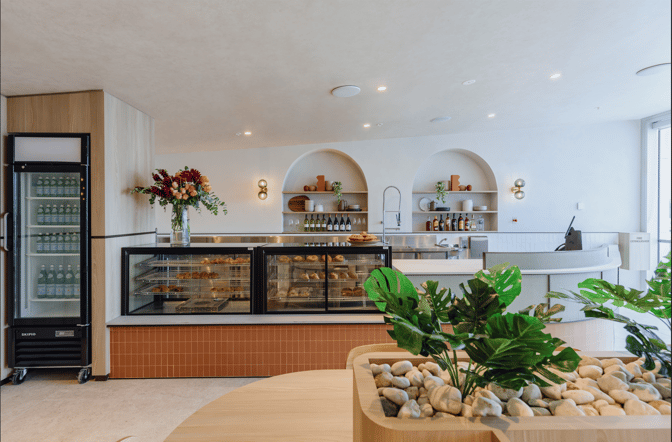The Plaza Premium Lounge at Sydney Airport features a self-serve food area with refrigerated drinks, pastries, and a selection of wines.