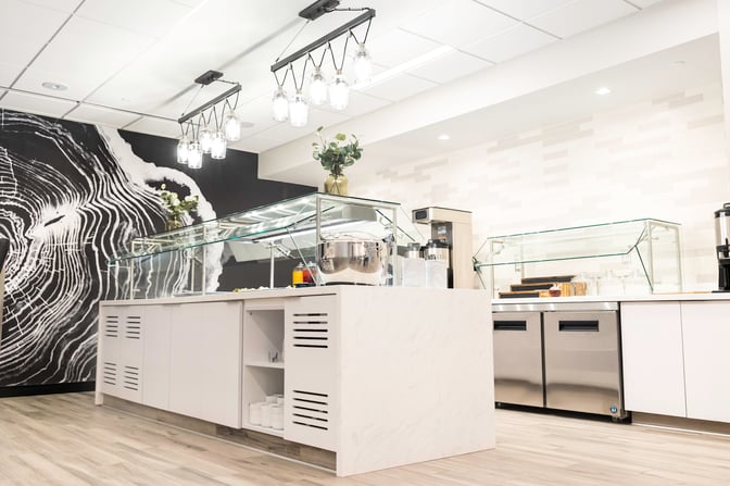 The food area in the Escape Lounge at Syracuse Hancock International Airport features self-serve stations with various dining options.