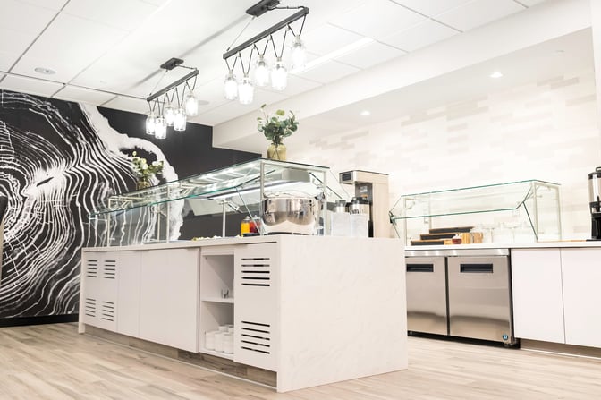 The food area in the Escape Lounge at Syracuse Hancock International Airport features self-serve stations with various dining options.