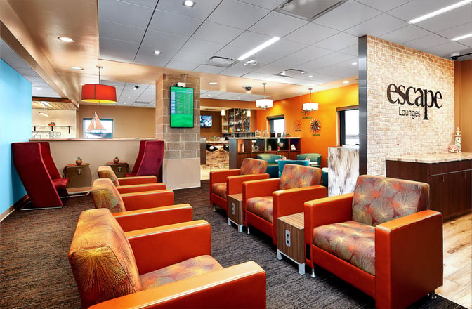The seating area in the Escape Lounge at Rhode Island T. F. Green Airport features comfortable chairs and a view of the bar.