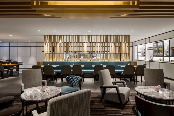 The Plaza Premium Lounge at Taiwan Taoyuan International Airport features comfortable seating with tables and a visible self-serve food area.