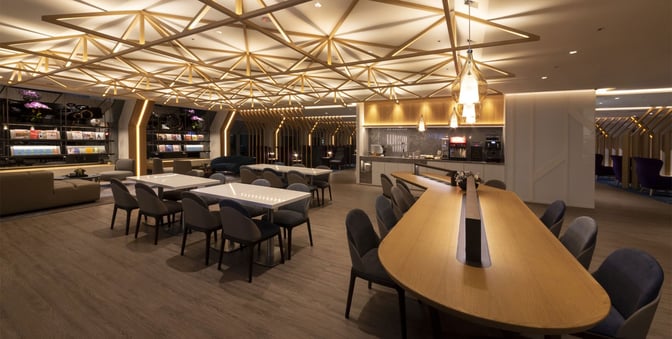 The Oriental Club Lounge at Taiwan Taoyuan International Airport features seating areas, a self-serve beverage station, and a magazine display.
