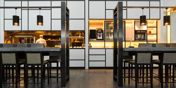 The Plaza Premium Lounge features a modern design with high tables, bar stools, and a sleek servi...