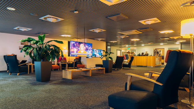 The Tallinn Airport LHV Lounge features comfortable seating with a television area and a reception desk for guest assistance.