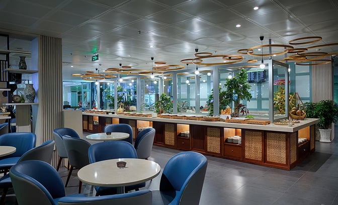 The Le Saigonnais Business Lounge at Tan Son Nhat Airport features a self-serve food area with seating and decorative elements.