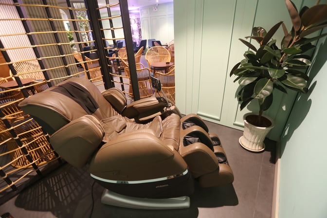 A massage chair is available for relaxation in a corner of Le Saigonnais Business Lounge, adjacent to seating areas.