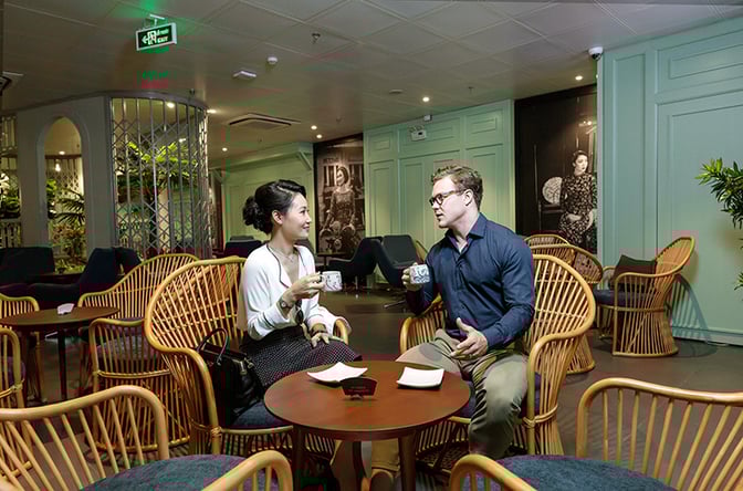 Seating area in Le Saigonnais Business Lounge features wicker chairs and tables, providing a relaxed space for conversation and refreshments.