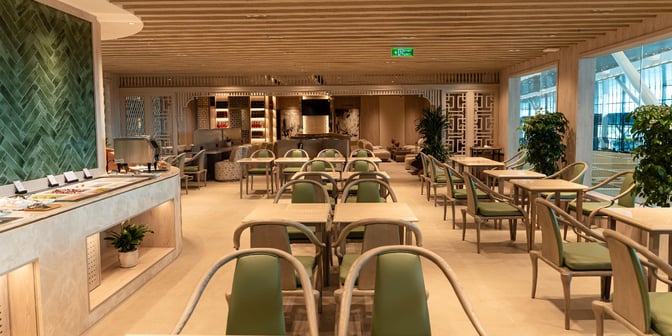 The SH Premium Lounge at Tan Son Nhat International Airport features a dining area with table seating and a self-serve food station.