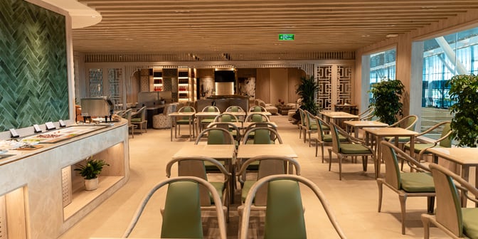 The SH Premium Lounge at Tan Son Nhat International Airport features a dining area with table seating and a self-serve food station.