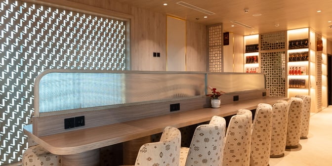 The SH Premium Lounge at Tan Son Nhat International Airport features a seating area with individual charging stations and decorative partitioning.