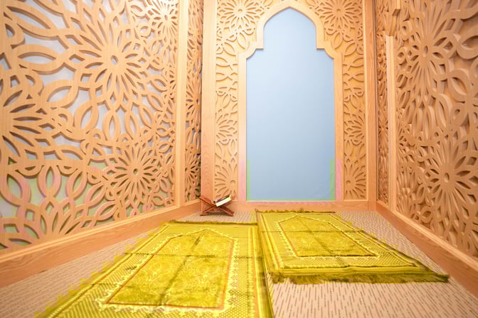 The prayer area at Jasmine Halal Lounge features intricately designed wooden panels and prayer mats, providing a serene space for worship.