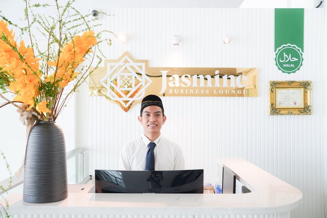 The reception area of Jasmine Business Lounge at Tan Son Nhat International Airport features a welcoming desk and Halal certification.