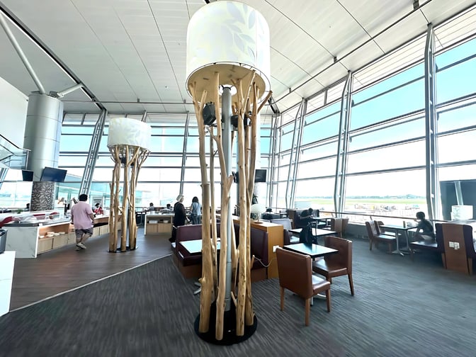 The Rose Business Lounge at Tan Son Nhat International Airport features seating areas with tables and views of the tarmac.