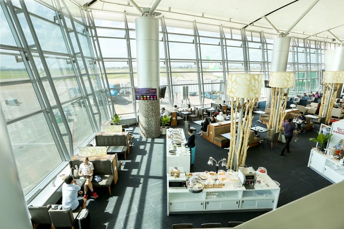 The Rose Business Lounge at Tan Son Nhat International Airport features spacious seating areas and a self-serve food station with airport views.