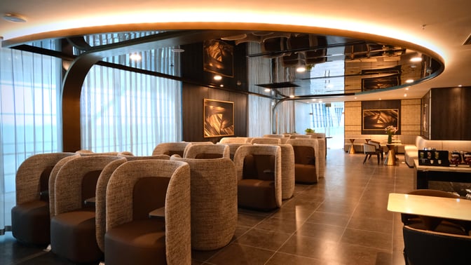 The SENS Business Lounge at Tan Son Nhat International Airport features semi-private seating pods and a dining area with tables.