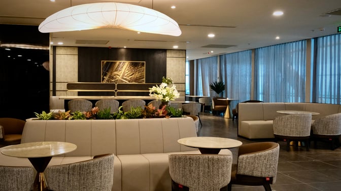 The SENS Business Lounge at Tan Son Nhat International Airport features comfortable seating areas with tables and decorative plants for relaxation.