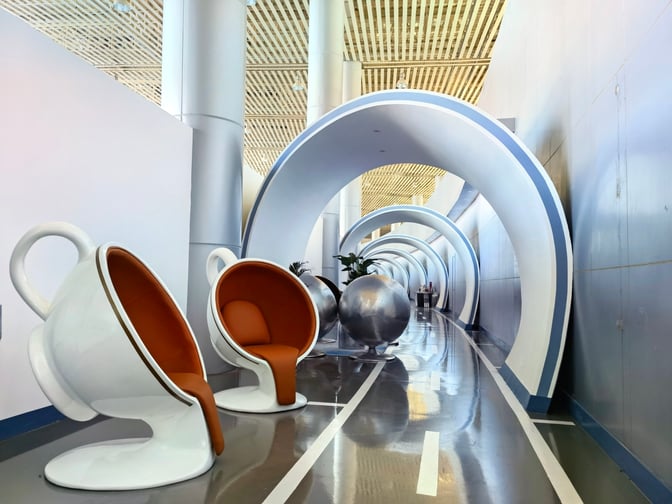 Unique cup-shaped seating and circular structures line the walkway in the First Class Lounge at Tangshan Sannühe Airport.