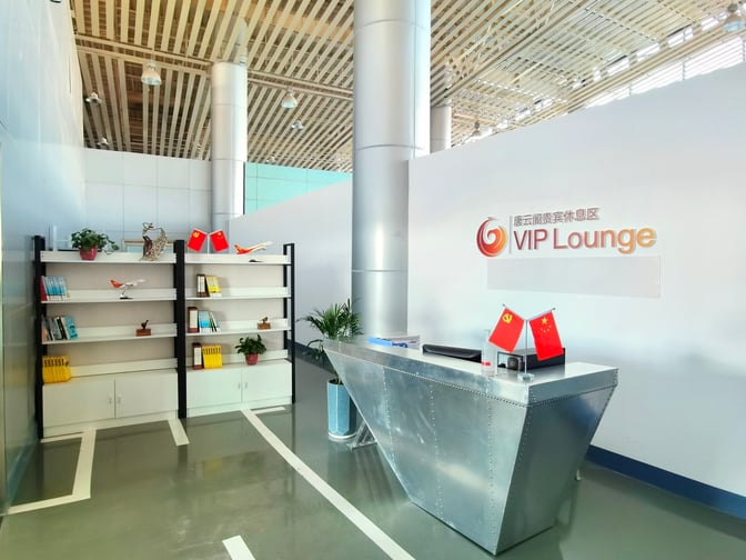 The VIP Lounge at Tangshan Sannühe Airport features a reception desk and a bookshelf with model airplanes and books.