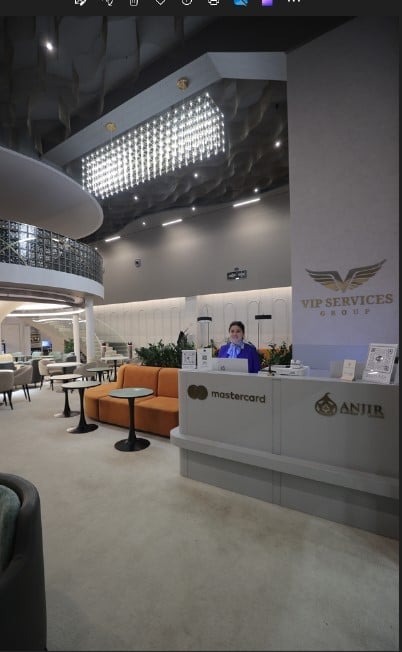 The Anjir Business Lounge at Tashkent International Airport features a reception desk with seating areas and tables for guests.