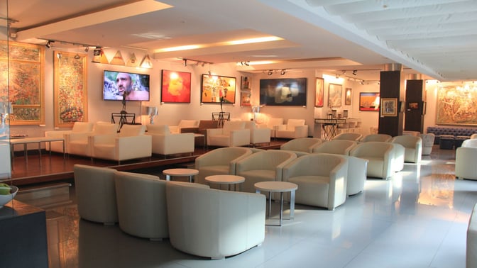 The Primeclass CIP/VIP Lounge at Tbilisi International Airport features comfortable seating areas with armchairs and tables, surrounded by artwork.