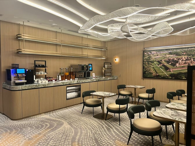 The Plaza Premium Lounge at Techo International Airport features a self-serve beverage station with seating for dining and relaxation.