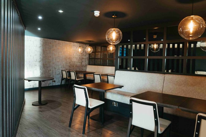 Booth seating in the Rockliffe Lounge at Teesside International Airport offers semi-private dining with tables and chairs for travelers.