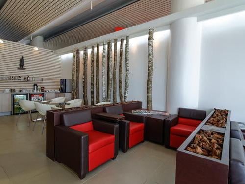 The Salones VIP Pacific Club at Temuco Airport features comfortable seating and a self-serve refreshment area with tables and chairs.