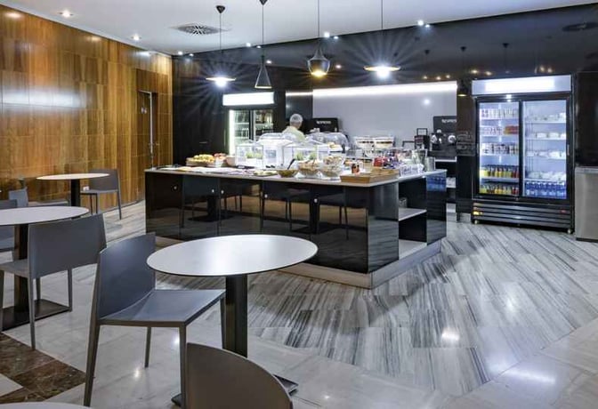 The food area in Sala Montaña Roja at Tenerife South Airport features self-serve stations with a variety of snacks and beverages.