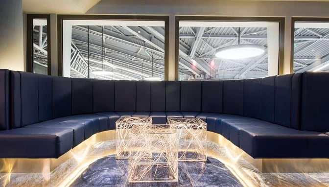Curved booth seating in the Skyserv Manolis Andronikos Lounge offers a semi-private space with views of the airport interior.