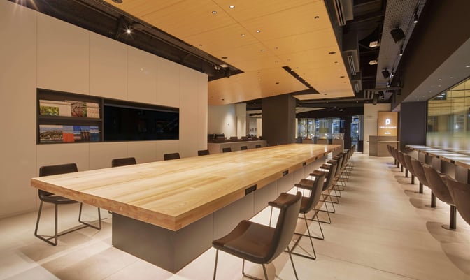 The POWER LOUNGE CENTRAL at Tokyo International Airport features a long communal table with seating, ideal for work or relaxation.