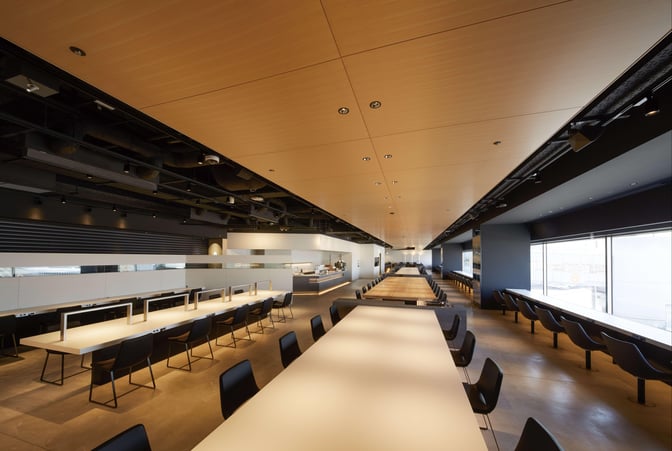 The POWER LOUNGE SOUTH at Tokyo International Airport features spacious communal tables and counter seating with views of the tarmac.