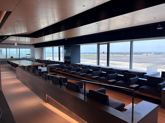 The POWER LOUNGE PREMIUM at Tokyo International Airport features seating with runway views, offering a comfortable space for travelers.