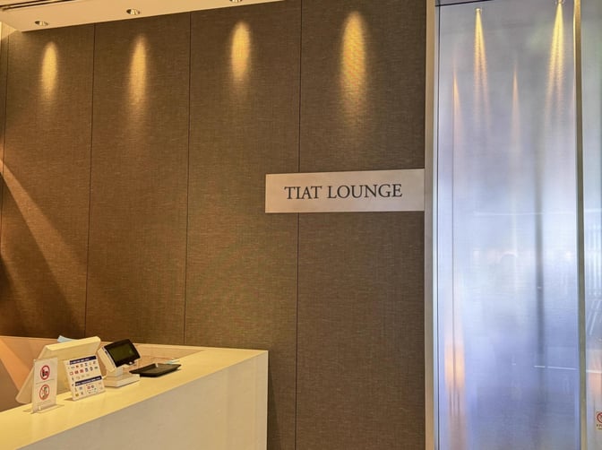 The entrance to TIAT Lounge at Tokyo International Airport features a reception desk with informational displays and signage.