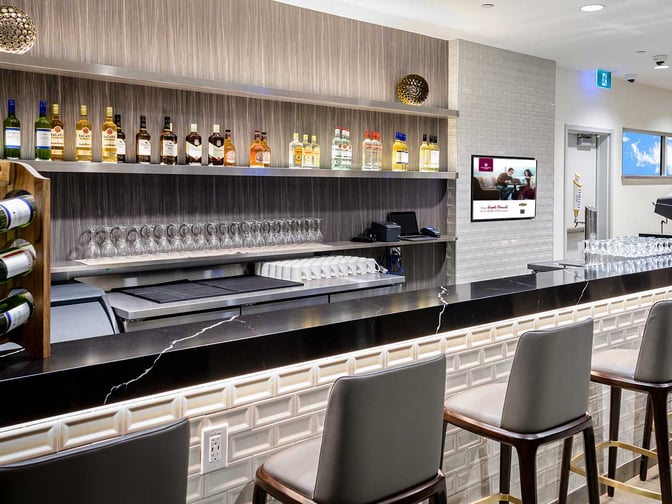 The bar at Plaza Premium Lounge, Toronto Pearson Airport, offers a selection of spirits and wines with counter seating available.