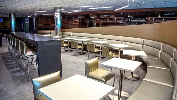 The Air France / KLM Lounge at Toronto Pearson features a seating area with booth-style benches and individual tables for dining.
