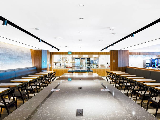 The Plaza Premium Lounge at Toronto Pearson offers a spacious dining area with booth seating and a self-serve food station.