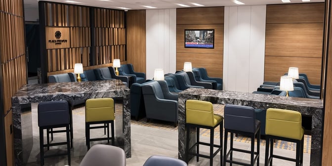 The Plaza Premium Lounge at Toronto Pearson International Airport features comfortable seating with tables and lamps, ideal for relaxation and work.