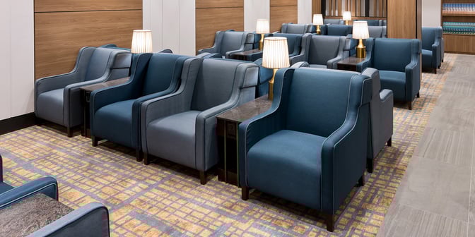 The seating area in Plaza Premium Lounge at Toronto Pearson offers comfortable armchairs with side tables and lamps for relaxation.