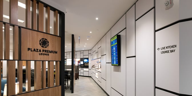 The entrance to the Plaza Premium Lounge at Toronto Pearson Airport features directional signage and a view into the lounge's interior.