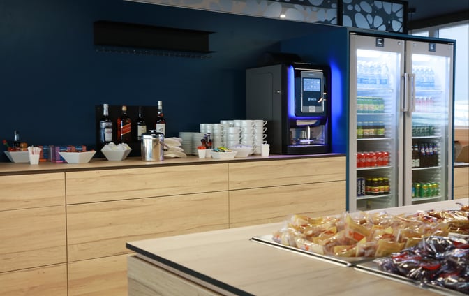 The beverage station at La Croix Du Sud lounge in Toulouse Blagnac Airport offers a selection of spirits, coffee, and chilled drinks.