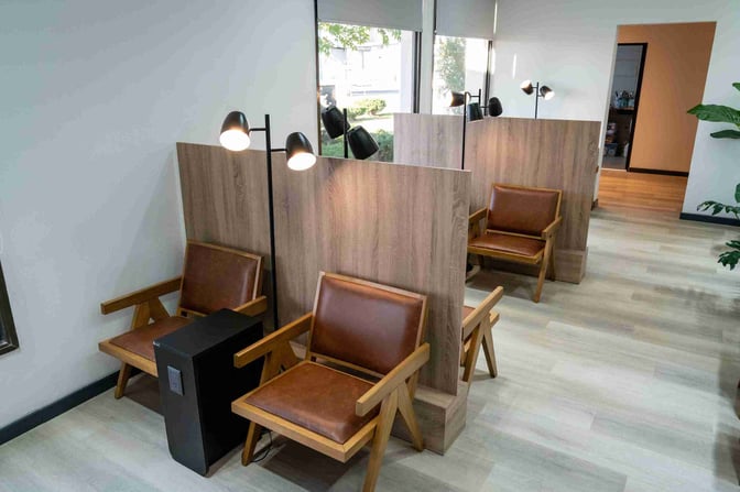 The seating area in W Lounge Trelew features individual chairs with privacy partitions and personal lighting, offering a comfortable space for travelers.