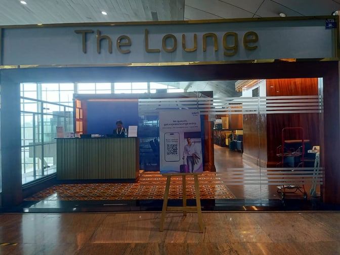 The entrance to The Lounge at Thiruvananthapuram International Airport features a reception desk and signage for express entry.