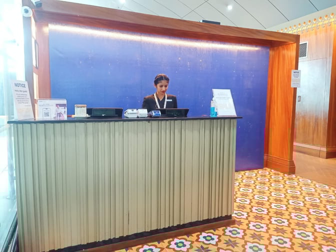The reception desk at The Lounge (International) in Thiruvananthapuram International Airport features check-in services with staff assistance.