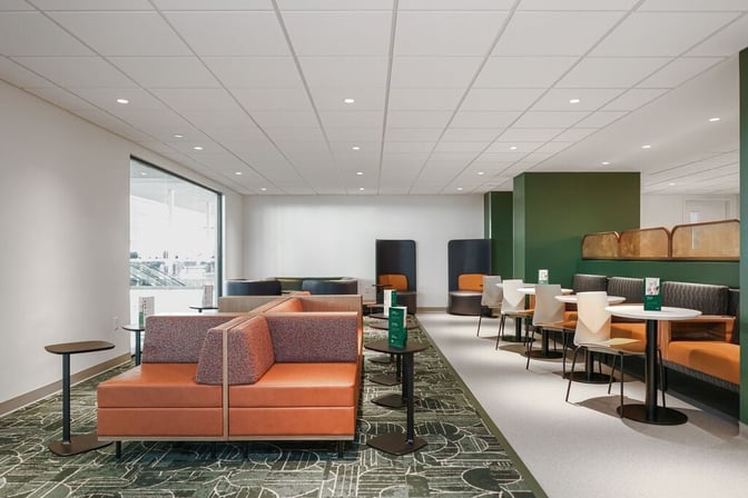 The seating area in Tulsa International Airport's Escape Lounge features booth and table seating, offering a comfortable space for travelers.