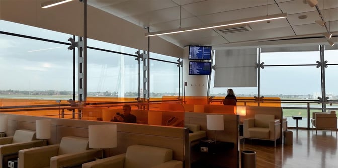The Piemonte Lounge at Turin-Caselle Airport features comfortable seating with views of the runway and flight information screens.