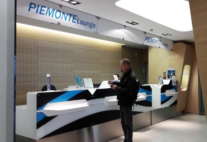 The Piemonte Lounge entrance at Turin-Caselle Airport features a reception desk with informational brochures and signage above.