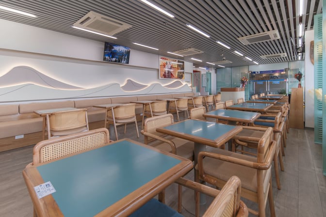 The SH Premium Lounge at Tuy Hoa Airport features a seating area with tables and chairs, providing a comfortable space for travelers.
