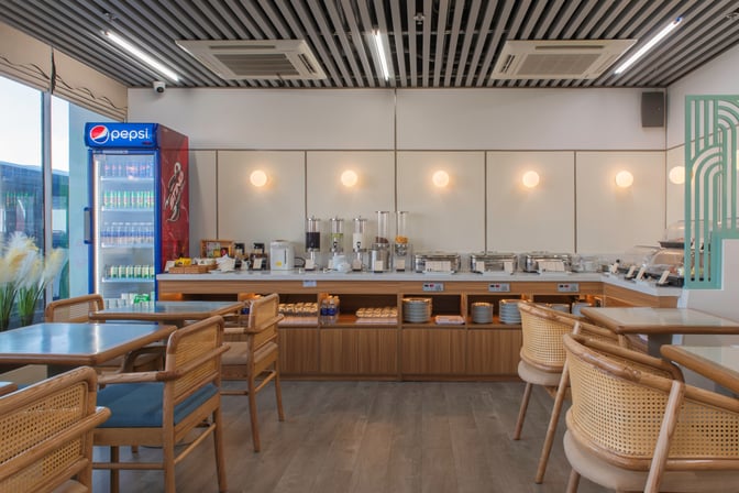 The SH Premium Lounge at Tuy Hoa Airport features a self-serve food area with beverage dispensers and a refrigerated drink display.
