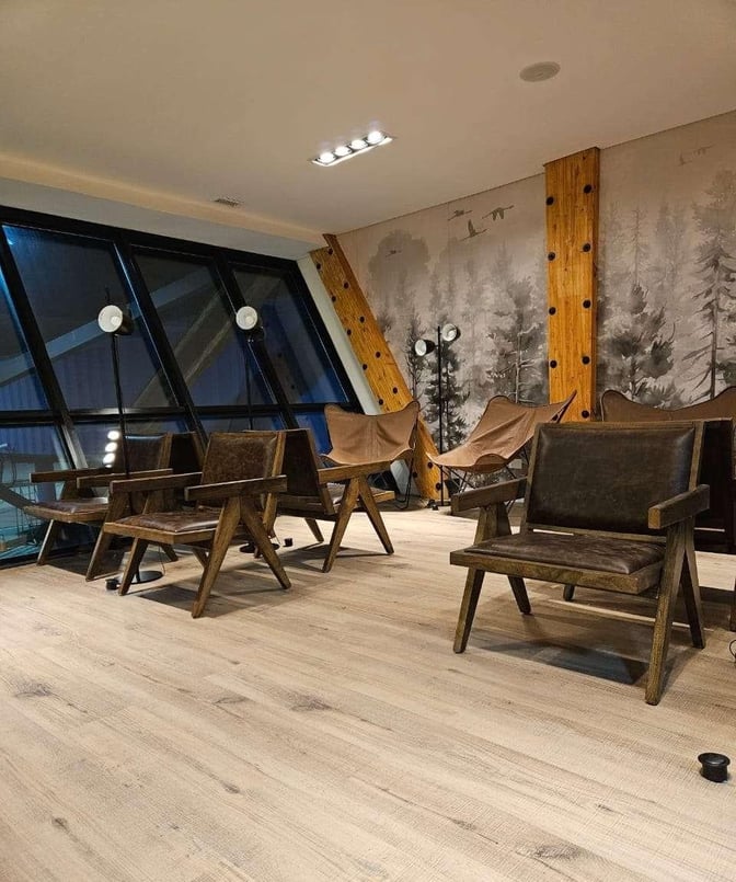 The seating area at W Lounge Ushuaia features comfortable chairs and large windows overlooking the airport, providing a relaxing environment.