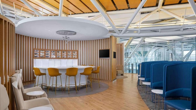 The SkyTeam Lounge at Vancouver International Airport features a circular bar with high stools and adjacent semi-private seating booths.